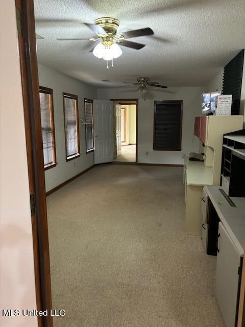 unfurnished living room with light carpet, a textured ceiling, and ceiling fan