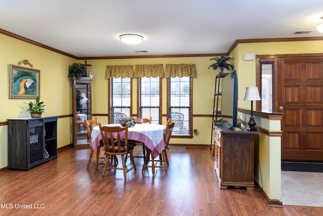 dining space featuring crown molding and wood-type flooring