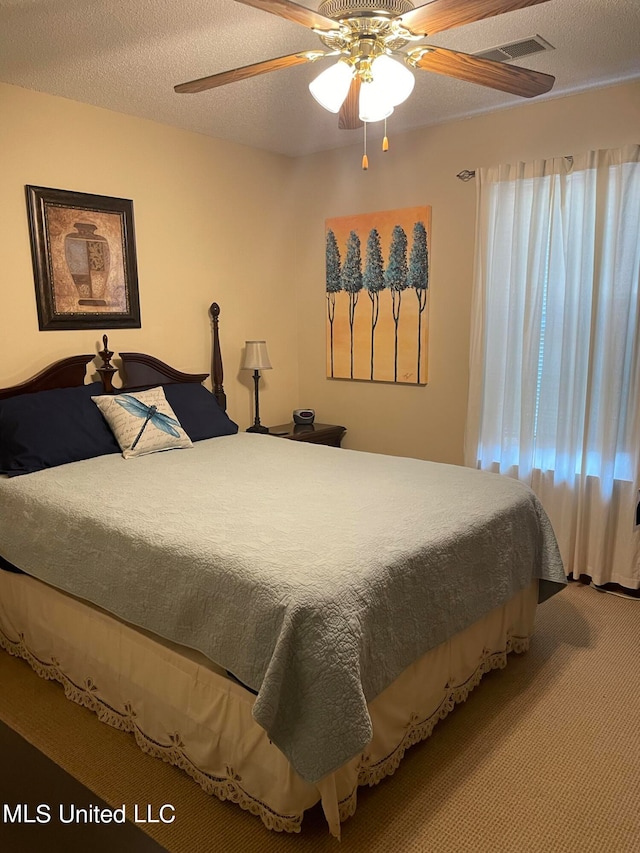 bedroom featuring carpet, a textured ceiling, and ceiling fan