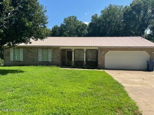 11319 Wren Rd, Hernando, MS 38632 - single story home featuring a garage, concrete driveway, a front yard, and a metal roof