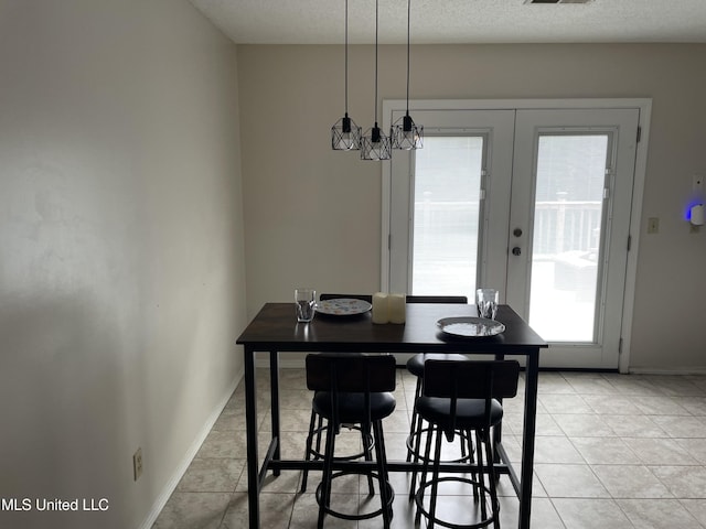 11319 Wren Rd, Hernando, MS 38632 - dining area with french doors, light tile patterned flooring, a chandelier, and a textured ceiling