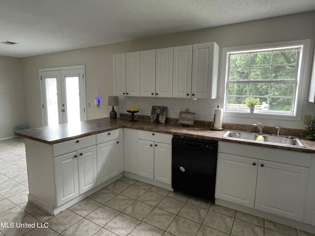 11319 Wren Rd, Hernando, MS 38632 - kitchen with black dishwasher, a peninsula, light tile patterned floors, white cabinetry, and a textured ceiling