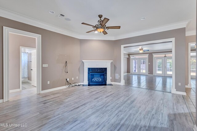 136 Sea Oaks Blvd, Long Beach, MS 39560 - unfurnished living room featuring ceiling fan, crown molding, light wood-style flooring, a fireplace, and french doors