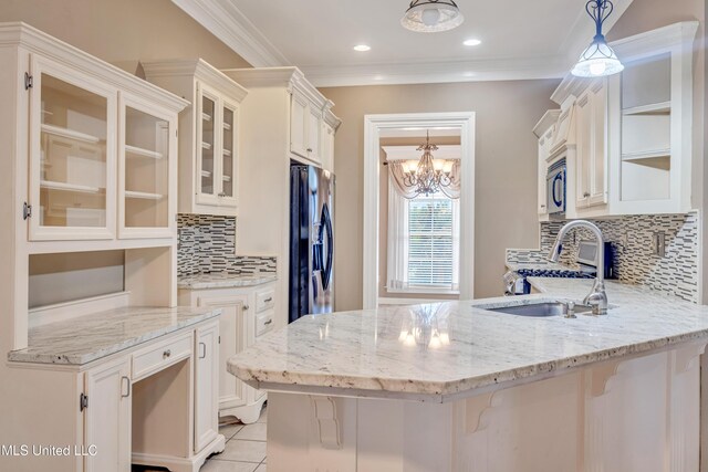 136 Sea Oaks Blvd, Long Beach, MS 39560 - kitchen featuring range, a peninsula, light stone counters, a chandelier, and ornamental molding