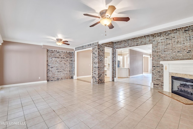 136 Sea Oaks Blvd, Long Beach, MS 39560 - unfurnished living room featuring a ceiling fan, brick wall, light tile patterned floors, ornamental molding, and a fireplace