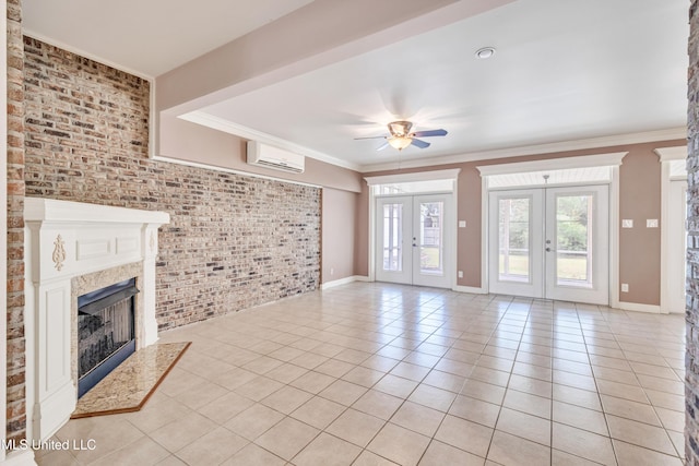 unfurnished living room featuring french doors, an AC wall unit, ceiling fan, light tile patterned floors, and brick wall