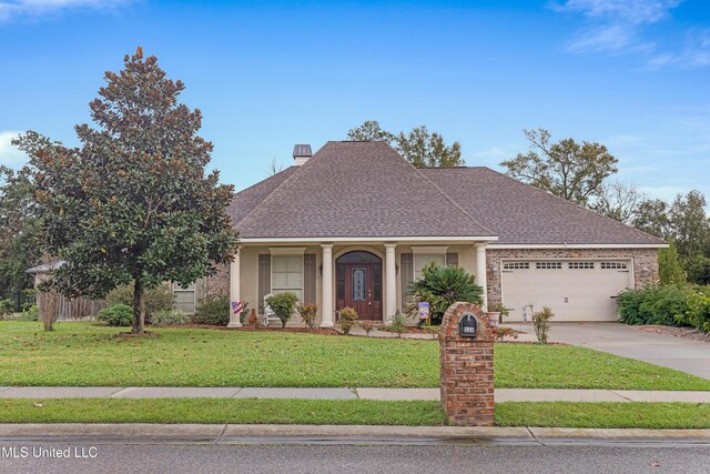 136 Sea Oaks Blvd, Long Beach, MS 39560 - view of front facade featuring an attached garage, concrete driveway, a front yard, and roof with shingles