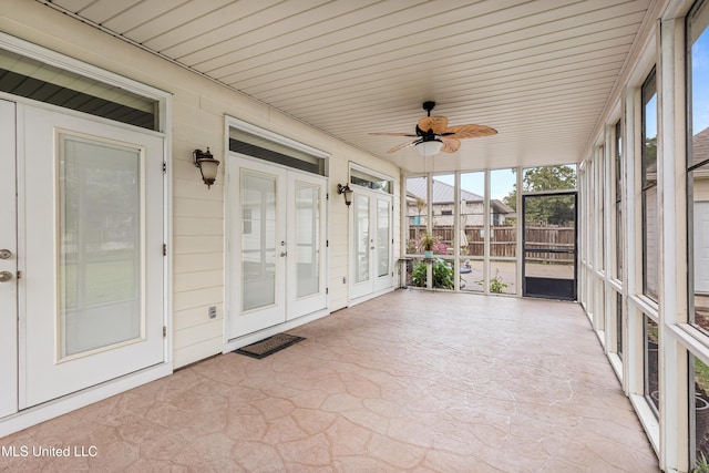 unfurnished sunroom with ceiling fan