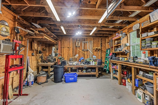 interior space featuring a workshop area, wood walls, and concrete flooring