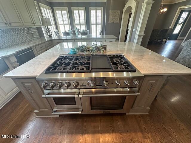 113 Hastings Ave, Brandon, MS 39042 - kitchen featuring arched walkways, dark wood-style floors, range with two ovens, and backsplash