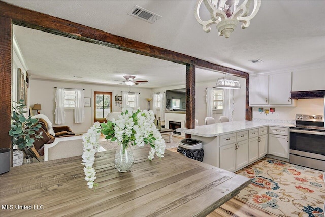 3341 Simpson Highway 13, Mendenhall, MS 39114 - kitchen featuring stainless steel electric range, open floor plan, light countertops, a peninsula, and a chandelier