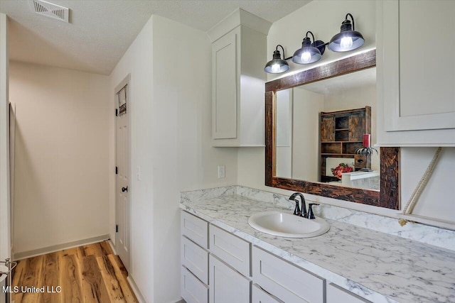 3341 Simpson Highway 13, Mendenhall, MS 39114 - bathroom featuring wood finished floors, vanity, a textured ceiling, and baseboards