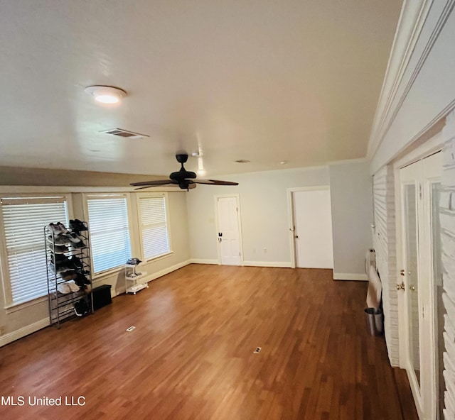 unfurnished living room featuring dark hardwood / wood-style floors, ceiling fan, and ornamental molding