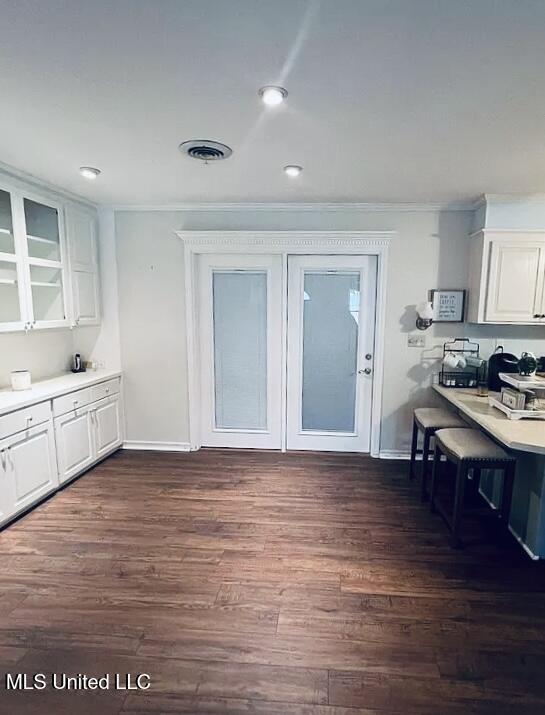 unfurnished dining area with dark hardwood / wood-style floors and ornamental molding