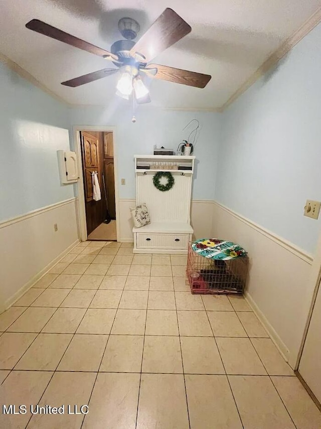 unfurnished bedroom featuring light tile patterned floors, ceiling fan, and ornamental molding