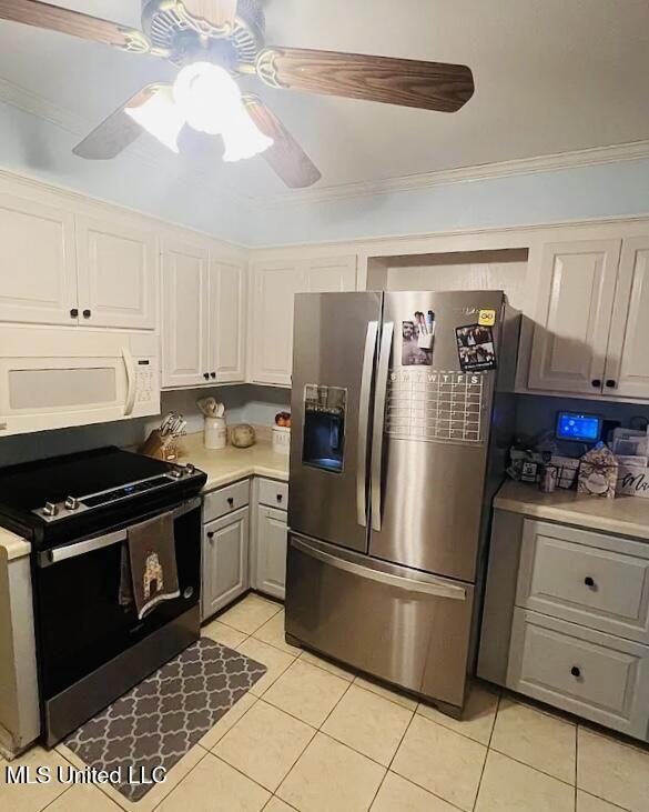 kitchen featuring gray cabinetry, stainless steel appliances, ceiling fan, crown molding, and light tile patterned floors