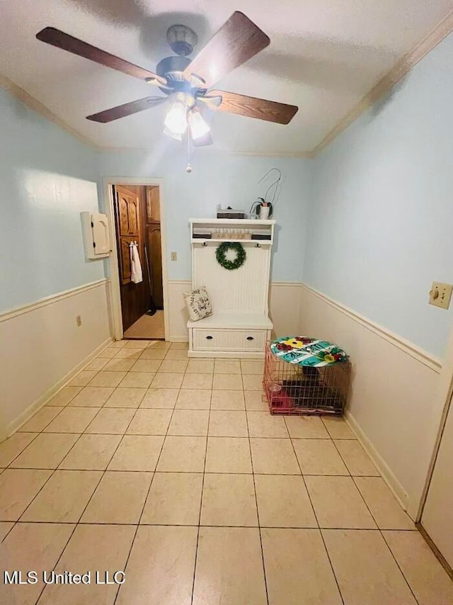 unfurnished bedroom featuring ceiling fan, light tile patterned floors, and ornamental molding