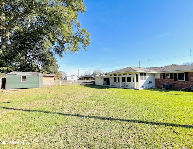 view of yard featuring central AC and a storage unit