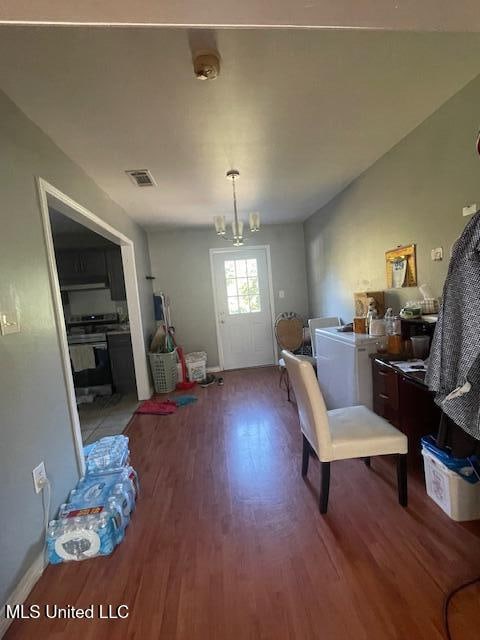 dining space featuring hardwood / wood-style flooring and a chandelier