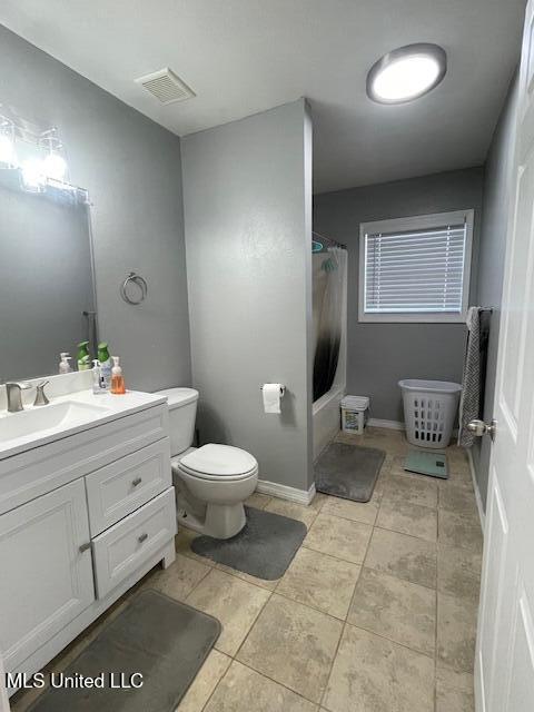 full bathroom featuring vanity, shower / bath combination with curtain, toilet, and tile patterned flooring