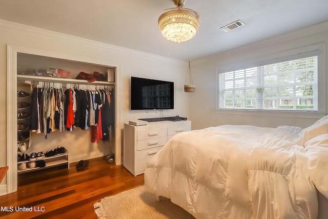 bedroom with crown molding, a closet, and dark hardwood / wood-style flooring