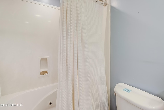 bathroom with shower / tub combo and toilet