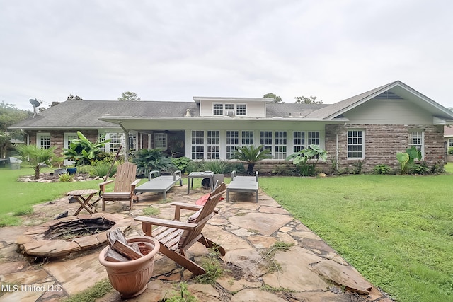 back of house with an outdoor fire pit, a patio, and a lawn