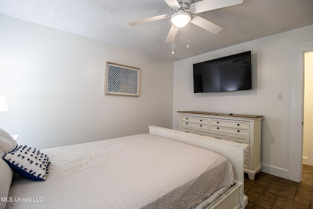 204 Trautman Ave, Long Beach, MS 39560 - bedroom with a textured ceiling, dark stone finish flooring, and ceiling fan