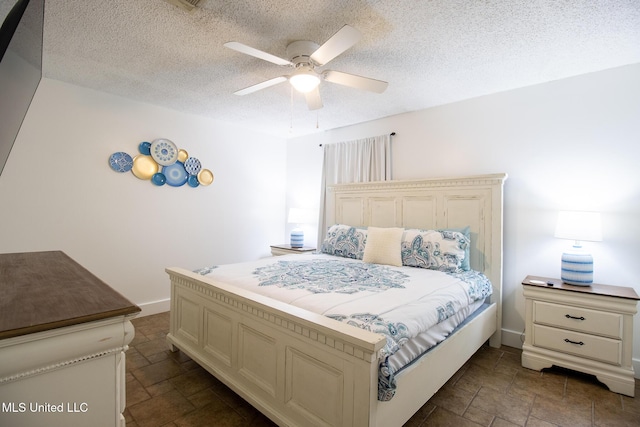 204 Trautman Ave, Long Beach, MS 39560 - bedroom featuring dark stone finish flooring, a textured ceiling, and a ceiling fan