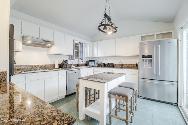 204 Trautman Ave, Long Beach, MS 39560 - kitchen with appliances with stainless steel finishes, under cabinet range hood, vaulted ceiling, dark stone countertops, and white cabinets