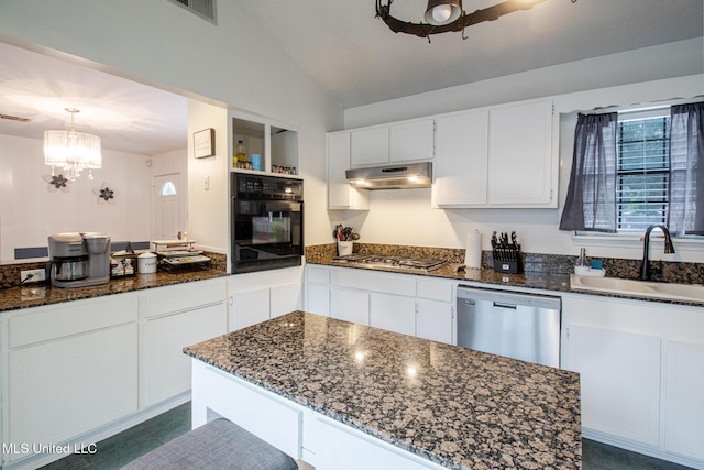 204 Trautman Ave, Long Beach, MS 39560 - kitchen with appliances with stainless steel finishes, under cabinet range hood, vaulted ceiling, white cabinetry, and dark stone countertops