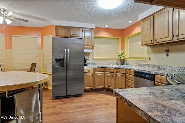 2804 Oakridge Cir, Gulfport, MS 39507 - kitchen featuring appliances with stainless steel finishes, light wood finished floors, a textured ceiling, a sink, and a ceiling fan