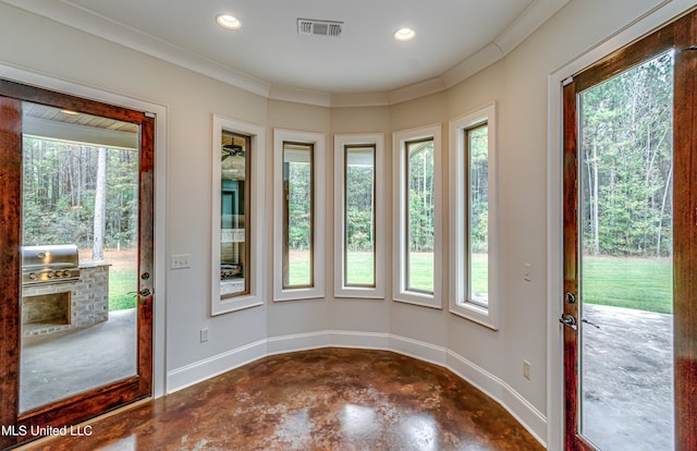 entryway featuring a wealth of natural light and ornamental molding