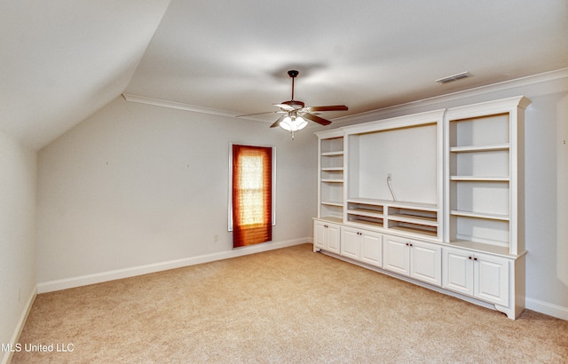 unfurnished living room featuring light colored carpet, ceiling fan, crown molding, and vaulted ceiling