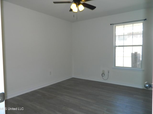 spare room featuring dark wood-style floors, baseboards, and a ceiling fan