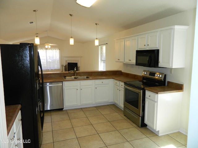 kitchen with dark countertops, vaulted ceiling, black appliances, white cabinetry, and a sink