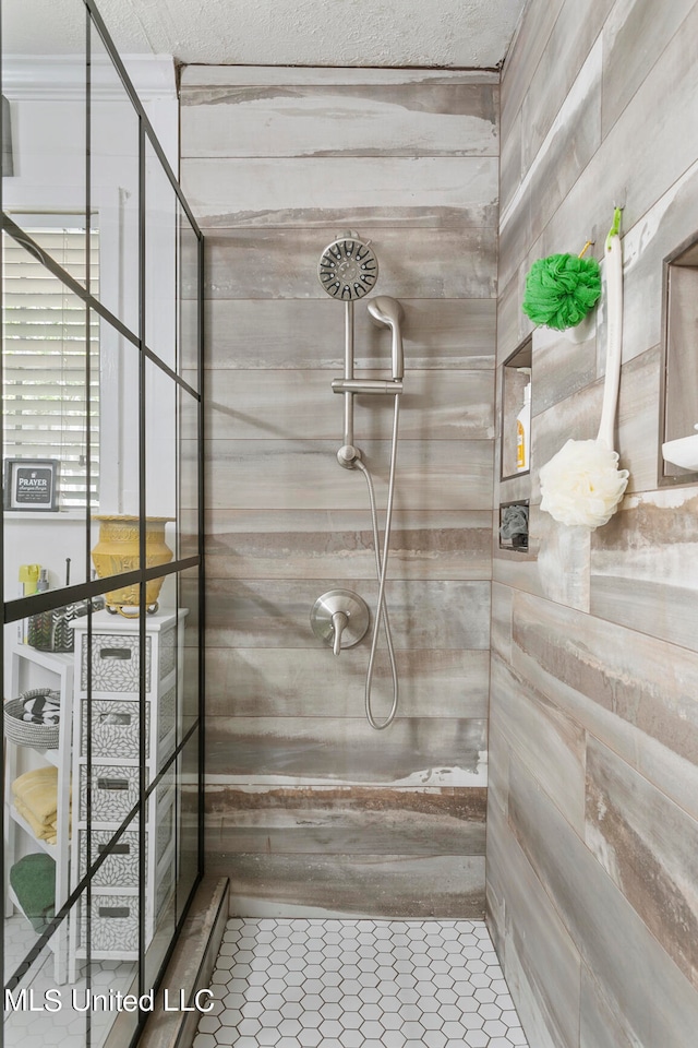 bathroom featuring a textured ceiling, tile patterned floors, and tiled shower