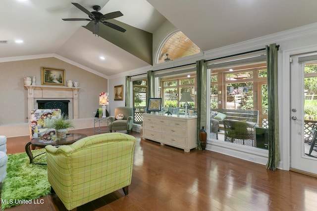 living room with lofted ceiling, dark wood-type flooring, crown molding, and ceiling fan