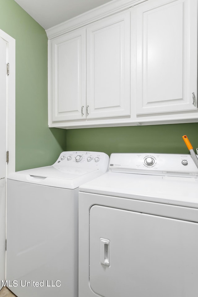 clothes washing area with independent washer and dryer and cabinets