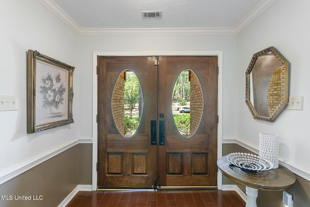 foyer with dark wood-type flooring, a textured ceiling, crown molding, and french doors