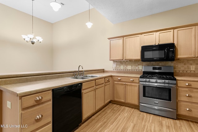 kitchen with tasteful backsplash, black appliances, sink, and decorative light fixtures