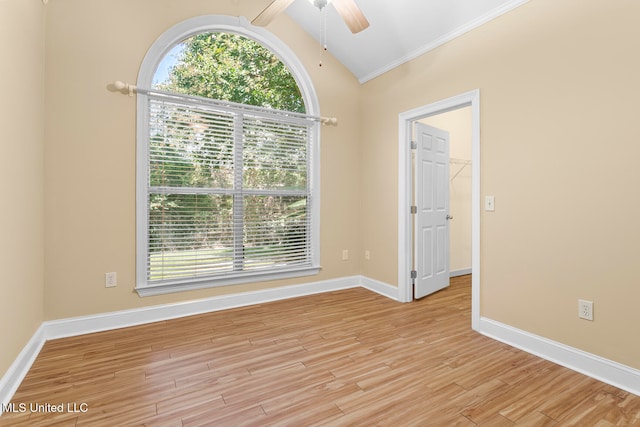 spare room featuring a healthy amount of sunlight, lofted ceiling with beams, light wood-type flooring, and ceiling fan