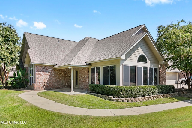 rear view of house featuring a garage and a lawn