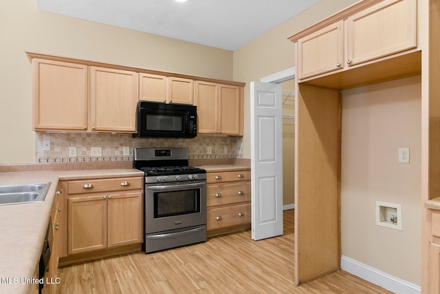 kitchen featuring stainless steel range with gas stovetop, light hardwood / wood-style floors, backsplash, and light brown cabinets