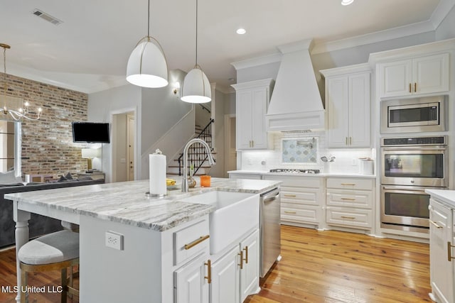 133 Saddlebrook Cv, Madison, MS 39110 - kitchen with stainless steel appliances, a sink, visible vents, custom exhaust hood, and crown molding