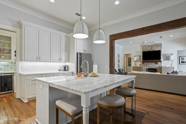 133 Saddlebrook Cv, Madison, MS 39110 - kitchen with stainless steel fridge, a kitchen bar, white cabinetry, and wine cooler