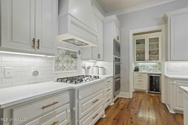 133 Saddlebrook Cv, Madison, MS 39110 - kitchen with wine cooler, backsplash, premium range hood, appliances with stainless steel finishes, and white cabinetry