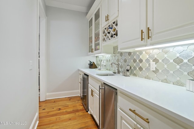 133 Saddlebrook Cv, Madison, MS 39110 - kitchen with backsplash, light countertops, a sink, baseboards, and light wood-style flooring