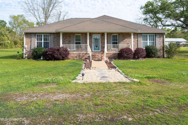 ranch-style home featuring covered porch and a front yard