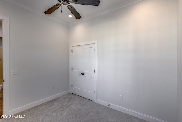 carpeted empty room with ceiling fan and crown molding